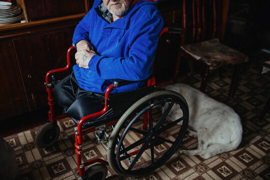 Physically disabled man on wheelchair in living room 