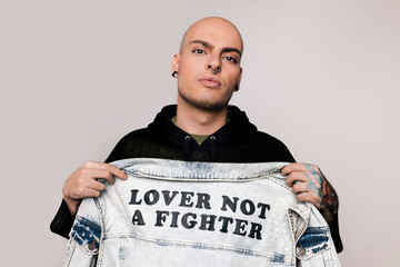 Alternative young man showing a jeans jacket with a message