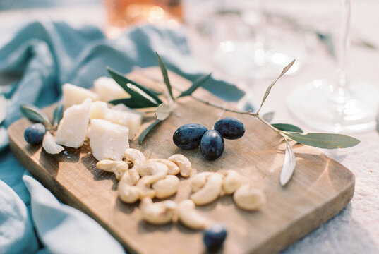 cheese and nuts on a wooden plate