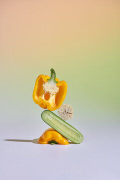 Plant art composition. Abstract balancing structure made of sliced cucumbers, garlic and bell peppers