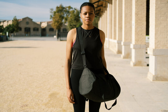 Black woman in activewear with sports bag