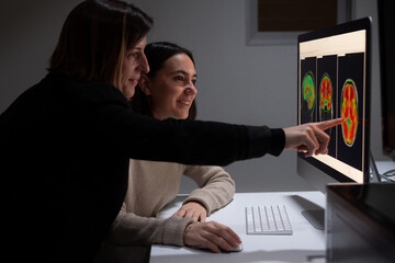 Researchers analyzing brain scans in lab