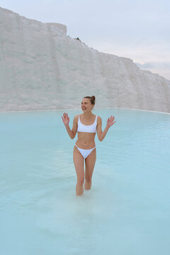a girl walks in a swimsuit on the water of a beautiful azure color