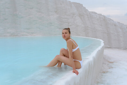 a girl walks in a swimsuit on the water of a beautiful azure color