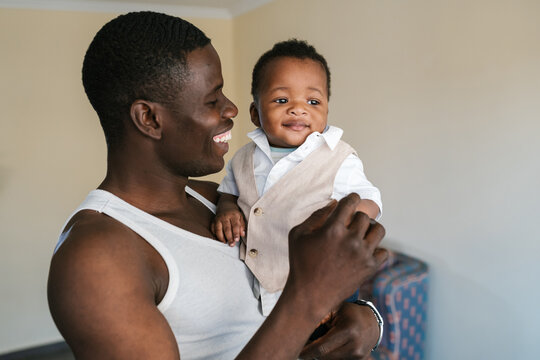 Cheerful black father with baby at home