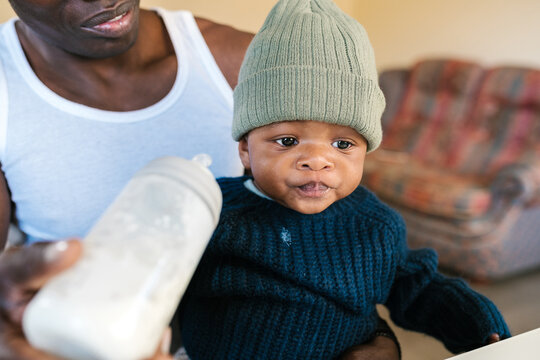 Crop father trying to feed toddler