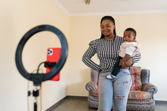 Smiling mother with son recording video on smartphone