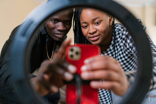 Couple taking selfie of smartphone on ring lamp