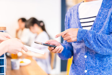 飲食店で電子マネー決済をする男性