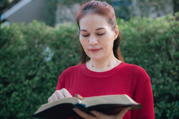 Asian woman reading and studying the bible.