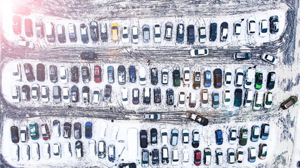 Bird's-eye view of parked cars in winter. Lots of cars in the parking lot during the winter snowfall