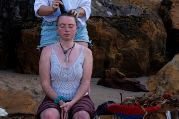 A young woman with many freckles getting her head shaved 