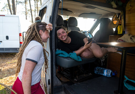 Two sweet girls camping with their van in a forrest 
