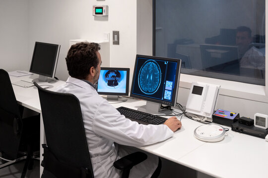 Researcher working on some brain scans at computer in the lab