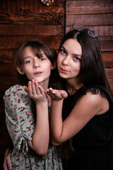 Two cute sisters blow a kiss to the camera.