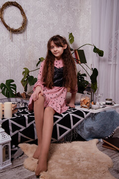 A cute little girl sits at home in a room on pallets. Breakfast.