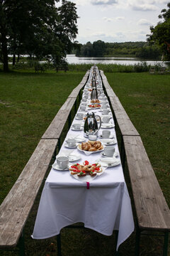 Long table set up by a lake in the garden