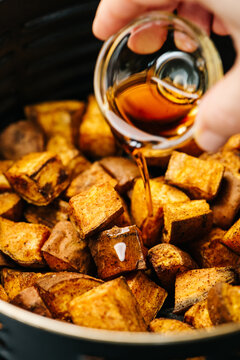 Pouring maple over sweet potatoes
