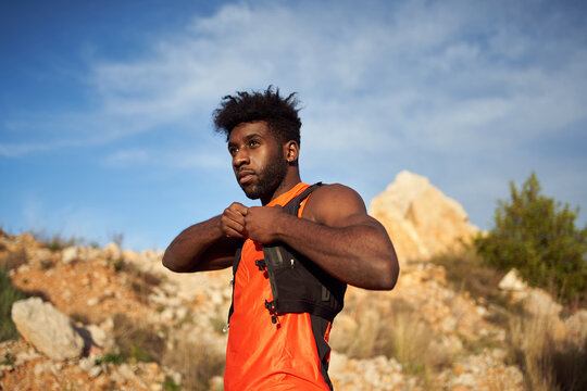 Fit black man warming up body before training