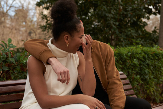Portrait of a multiracial couple at a bench park