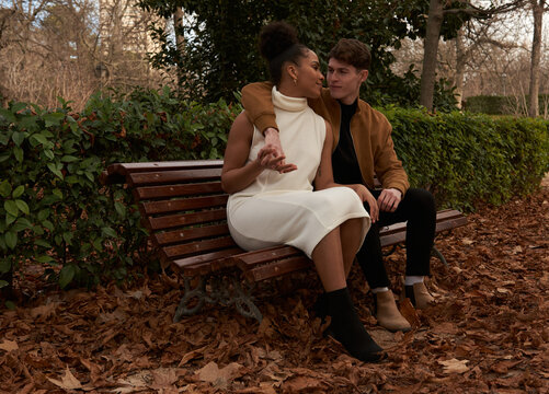 Multiracial couple at a bench park