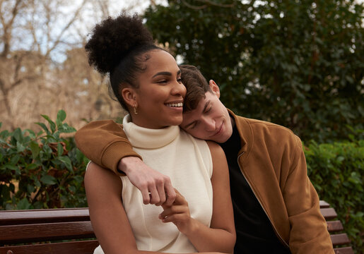 Portrait of a multiracial couple at a bench park