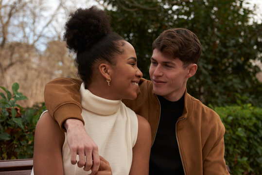 Portrait of a multiracial couple at a bench park