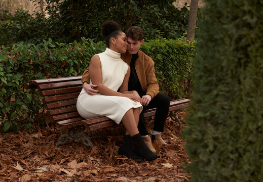 Multiracial couple at a bench park