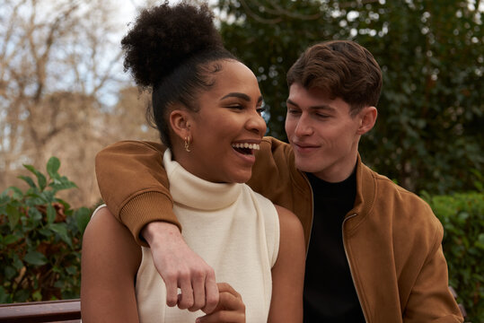 Portrait of a multiracial couple at a bench park