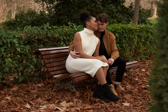 Multiracial couple at a bench park