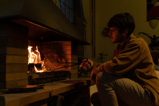 Man lighting the fireplace at home