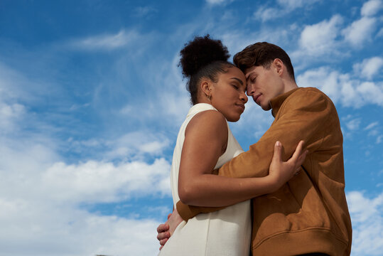 Couple hugging at a blue sky