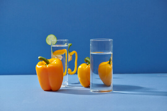 Bell pepper and two water glasses on blue table
