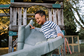Young Boy With Down Syndrome Going Down Slide