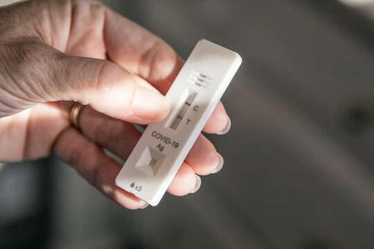 Woman Holding Positive Covid-19 Test - Powered by Adobe