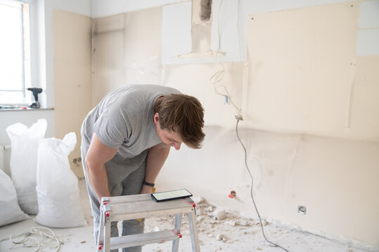 Looking Smartphone Screen While Doing Renovation