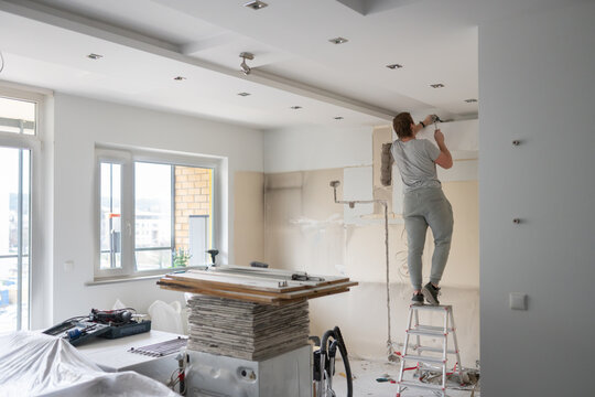 Flat Renovation. Man Standing On The Ladder