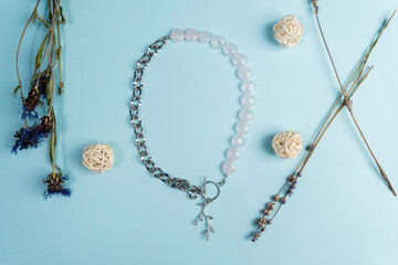 Fototapeta premium Handmade jewellery. Silver chain necklace and white quartz stones, on a blue background