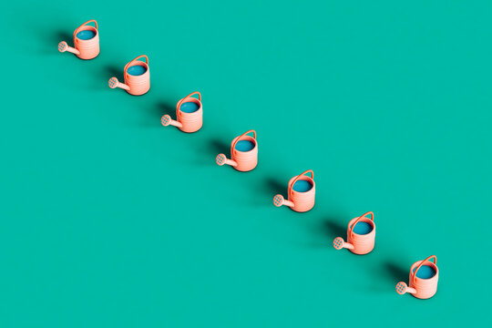 a row of Pink watering can on green background