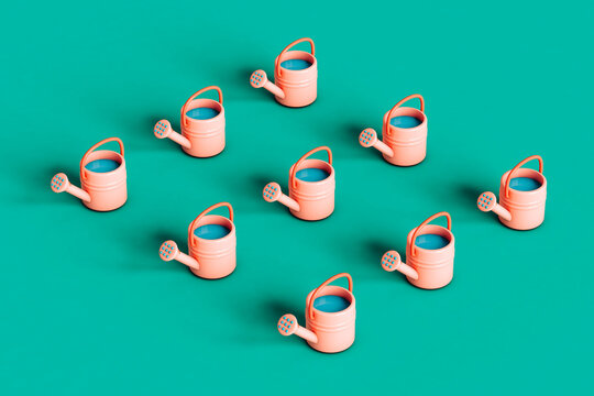 gardening concept.Pink watering can on green background