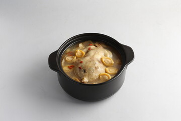 freshly hot stewed whole kampong chicken with abalone seafood in clay pot herbal soup on white background