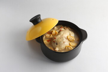 freshly hot stewed whole kampong chicken with abalone seafood in clay pot herbal soup on white background restaurant banquet halal menu