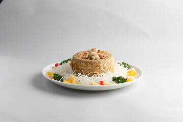 deep fried crispy yam ring with stir fried seafood meat vegetable and cashew nut in sauce and white vermicelli on white background chinese banquet menu