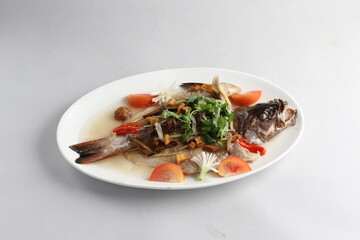 teo chew steamed whole fresh red grouper fish in salted vegetable tomato sauce chinese banquet halal seafood menu on white background