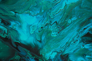 Fluid Art. Green and blue abstract wave swirls on black background. Marble effect background or texture