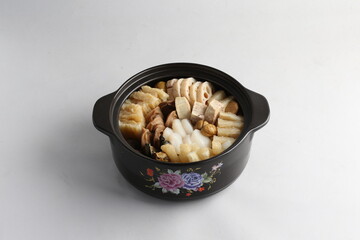 freshly hot stewed Peng cai with  seafood and meat in herbal sauce clay pot and yellow cover on white background Chinese traditional menu