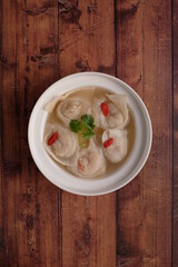 chef handmade fresh seafood meat pork ball dumpling in frozen and hot soup bowl on wood background top view chinese menu