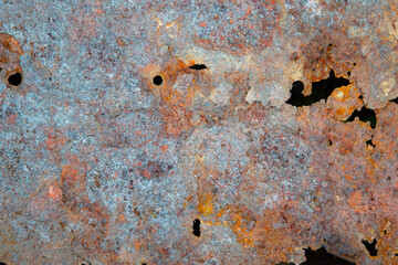 grunge background: rust on an old painted metal surface, holes from through corrosion of steel, toning