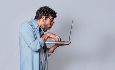 Handsome guy checking his laptop isolated, surprised man checking his laptop, guy with laptop.