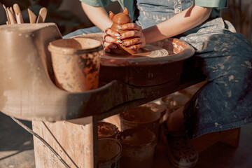Clay artist modeling product on potter wheel in workshop